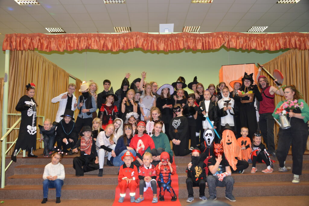 Hromadá fotografie všech účastníků v halloweenských maskách a kostýmech