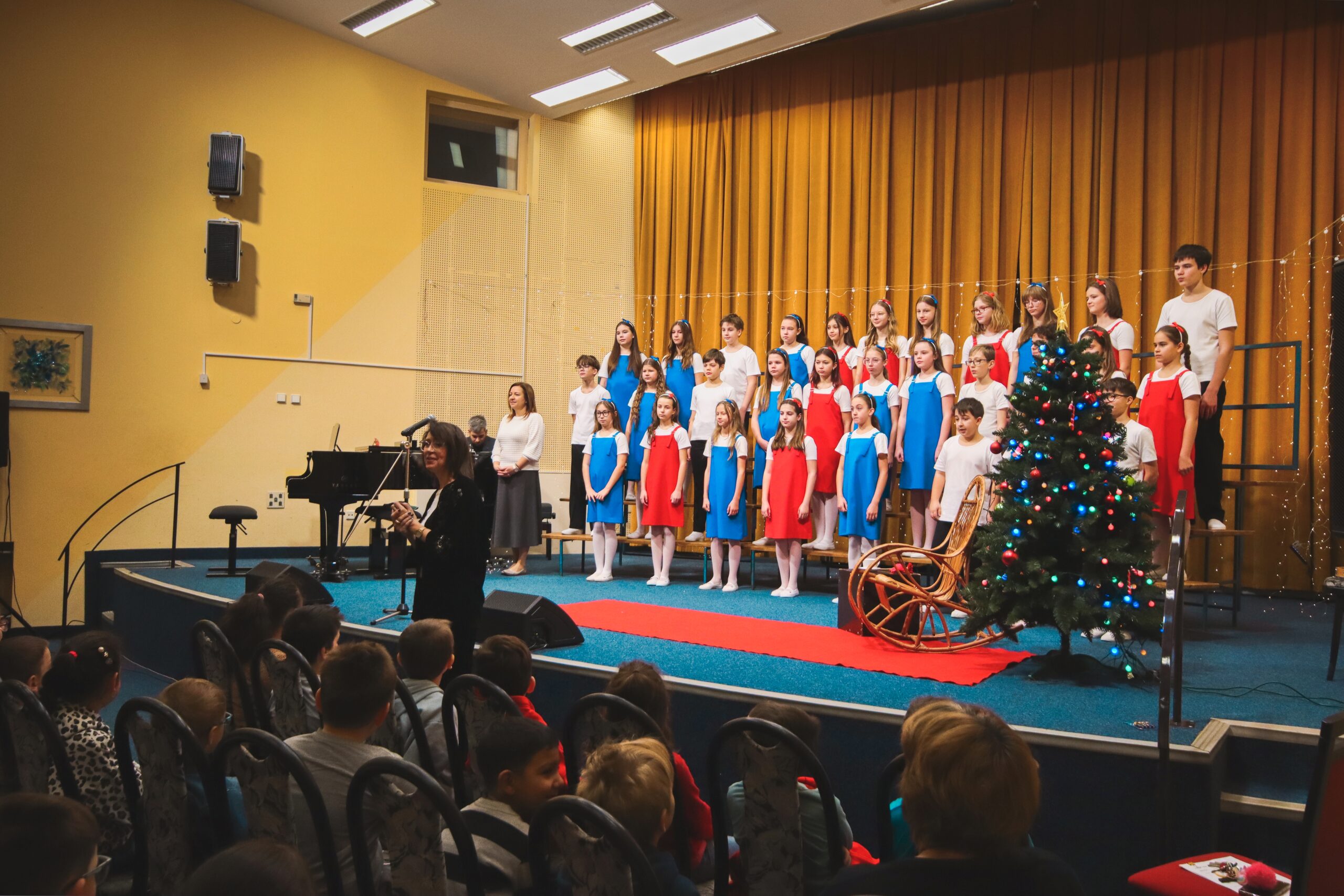 Zaplněnému koncertnímu sálu zpíval Přípravný sbor Permoník, na začátku koncertu žáky vítá autorka scénáře koncertu Radka Veselá